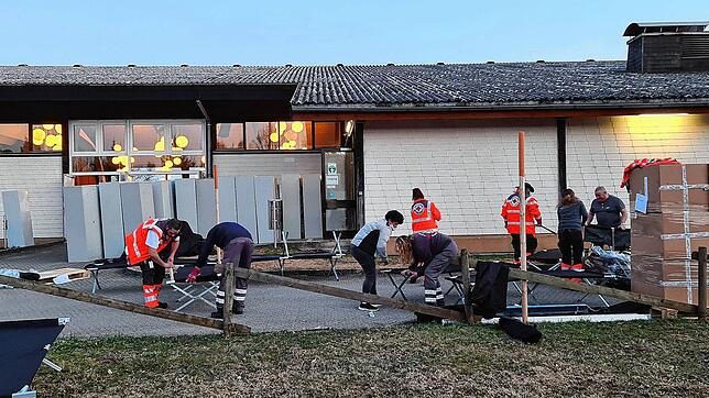 Helfer bauen vor der Hotzenwaldhalle Feldbetten zusammen. Rund 80 Personen sollen immer für kurze Zeit in der Halle untergebracht werden ...