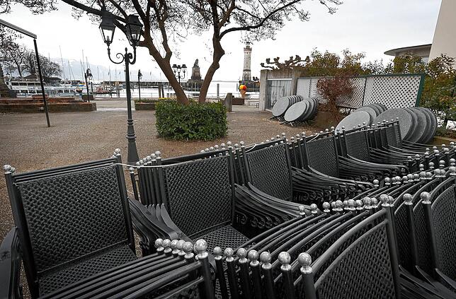 Auch in Lindau sind Tische und Stühle auf der Terrasse eines geschlossenen Restaurants im Hafen zusammengestellt.