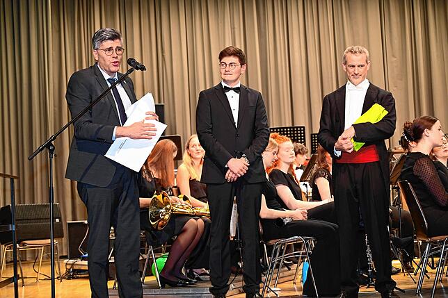 Landrat Martin Kistler (von links) übergibt als Dank für das Konzert eine Spende an Lean Spitz (Vorsitzender des VJO) und Julian Gibbons ...