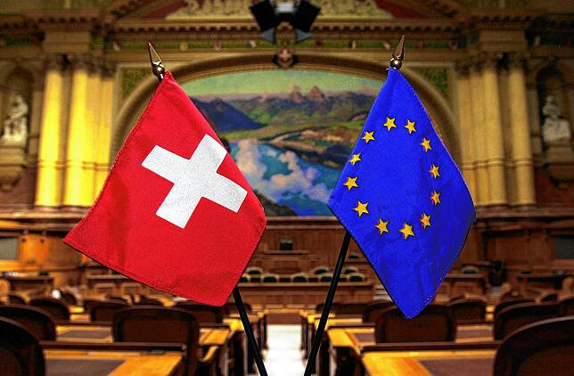 Fähnchen der EU und der Schweiz stehen im Nationalratssaal der Schweiz in Bern. Die Beziehungen zwischen Deutschland und der Schweiz ...