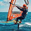Windfoil-Surf-Weltmeister Sebastian Kördel schwebt mit seinem Brett geradezu über dem Wasser.