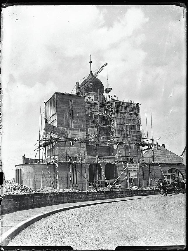 Kranarbeiten auf der Baustelle. Die neue Kirche hat schon gut Form angenommen.