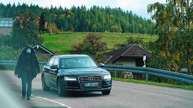 Eine Frau geht neben einem Fahrzeug mit Personenschützern durch Ibach im Hotzenwald, wo sich Alexej Nawalny derzeit aufhält.