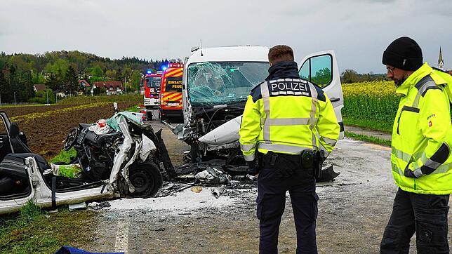 Einsatzkräfte der Polizei stehen an der Unfallstelle auf der Landstraße 286 bei Hoßkirch. Bei einem Zusammenprall eines Autos mit einem ...