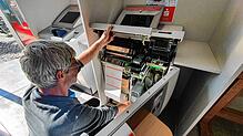Ein Mitarbeiter schließt einen Automaten in der Übergangsfiliale der Sparkasse Bad Säckingen an.