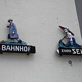 Zwei sympathische Wegweiser am Rathaus: Der Weg zum Bahnhof und See ist immer noch derselbe.