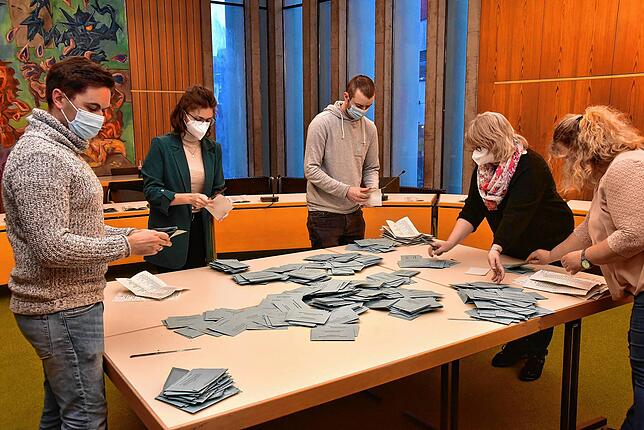 Im großen Sitzungssaal im Rathaus werden die Stimmzettel gezählt, die per Briefwahl eingegangen sind.