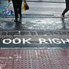 „Look right“-Markierungen für „schauen Sie rechts“ sin an einem Fußgängerüberweg auf einer Straße in London aufgebracht.