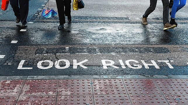 „Look right“-Markierungen für „schauen Sie rechts“ sin an einem Fußgängerüberweg auf einer Straße in London aufgebracht.