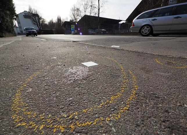 Auf der Straße nahe dem Recyclinghof (im Hintergrund) haben die Ermittler die Stelle markiert, wo dem Mann die tödlichen Stiche zugefügt ...