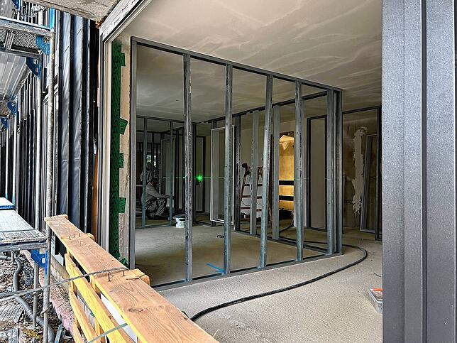 In Haus 3 fehlen noch die Fenster. Dafür vermessen die Bauarbeiter gerade, wo in dem Haus die Gipszwischenwände eingezogen werden müssen.