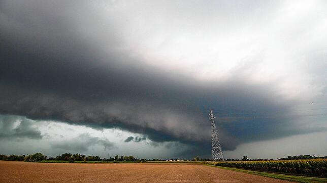 Eine dunkle Gewitterzelle zieht über ein Feld in Cremona in der Lombardei. Für die Region gibt es eine Unwetterwarnung, es werden ...
