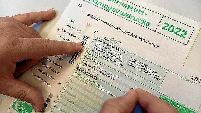 Ein Mann füllt den Vordruck für eine Einkommensteuererklärung aus. Nach der Abgabe der Erklärung musste er auf den Steuerbescheid des ...