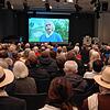 Vernissage zur Ausstellung &bdquo;Das trojanische Pferd&ldquo;. Künstler Peter Lenk spricht im gleichnamigen Film zum Publikum.