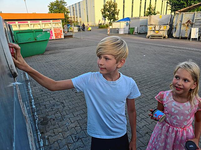 Ben und Maja Kuhn werfen begeistert Schraubgläser in den Weißglascontainer.
