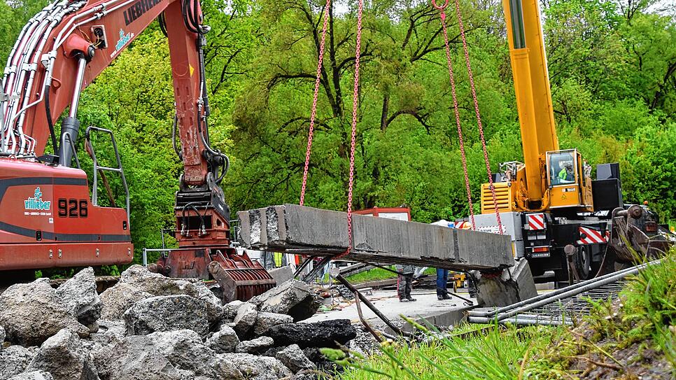 Der Autokran hebt den zweiten Streifen aus, aber ein Teil des Materials gibt nach. Das wird zügig mit seitlich auf die Brücke ablegen ...