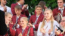 Die Musiker des Jugendblasorchesters bedanken sich wie auch Publikum mit einem stehenden Applaus beim musikalischen Leiter des Orchesters.