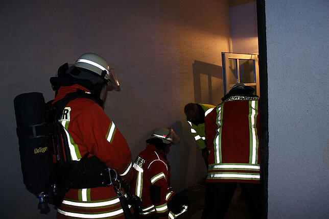 Vor dem Hintereingan des Rathaus II versuchen die Feuerwehrleute mit Klärwärter Dieter Schmidl, den Kanaldeckel zu öffnen.