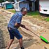 Dietmar Heuter versucht mit einer Schneeschaufel das Vorzelt seines Campingwagens vom schweren Schlamm zu befreien.