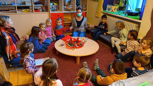Mit ihren Erzieherinnen Beata Sosnowska (links) und Elisa Vögele (Mitte) sitzen die Kinder der Sternschnuppen-am Nikolaustag im ...