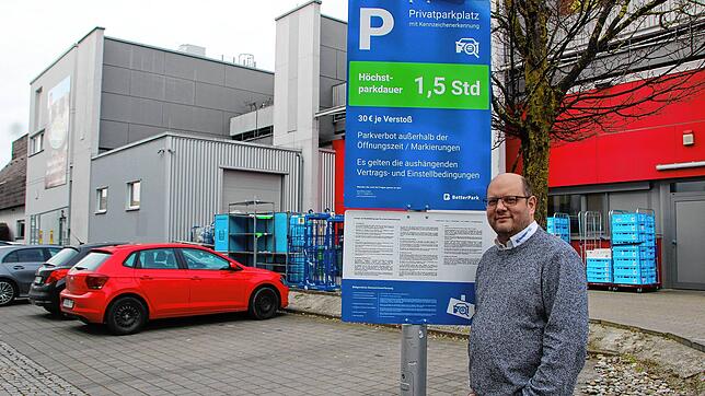 Matthias Schopf, Pressesprecher von Edeka Sulger, an einem der Schilder, die auf das Parksystem aufmerksam machen. Bild: Stefanie Nosswitz