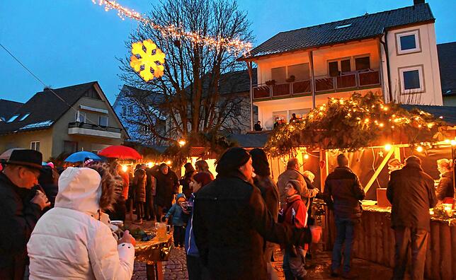 Lichter sorgen für Stimmung und auch wenn es regnet, kommen und gehen laufend viele Besucher.