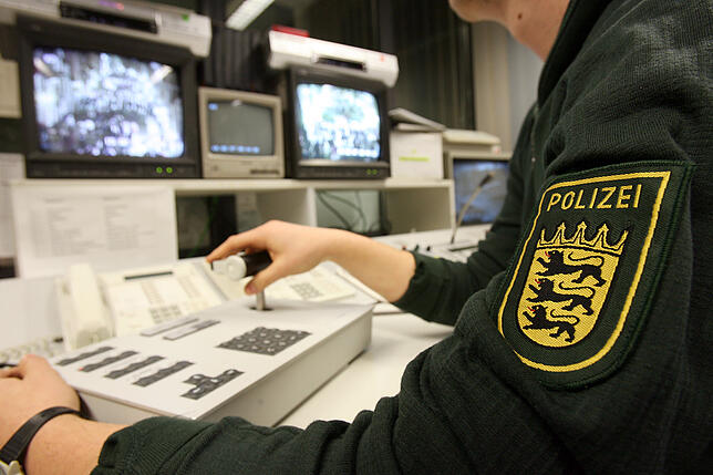 Ein Polizist kontrolliert an zwei Monitoren im Villinger Polizeirevier per Videoüberwachung die Menschenmassen in der Kneipenmeile der ...
