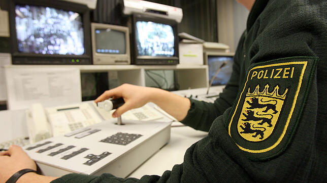 Ein Polizist kontrolliert an zwei Monitoren im Villinger Polizeirevier per Videoüberwachung die Menschenmassen in der Kneipenmeile der ...