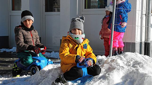 Matteo (vorne, gelbe Jacke) und Ahmad haben im Kindergarten &bdquo;Stadtzwerge&ldquo; Spaß im Schnee.