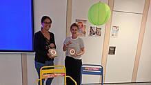 Ulrike Schwichtenberg (links) und Mira Krane stehen vor den bunten Stühlen, die bei der Veranstaltungsreihe Sommer im Städtle vor den ...