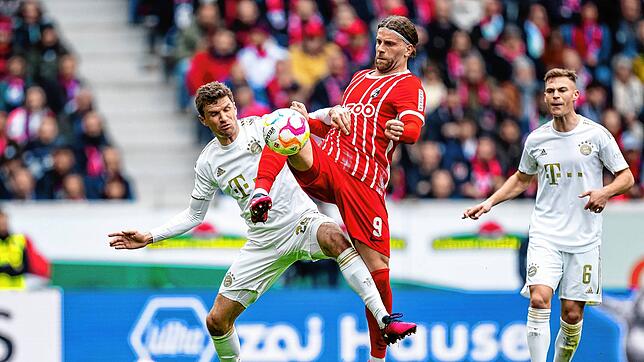 Münchens Thomas Müller (l) in Aktion gegen Freiburgs Lucas Höler.