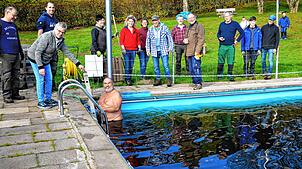 Im Höhenfreibad Schweigmatt: Freiwillige Helfer beobachten Thomas Jost, der im eisigen Wasser abtaucht, um das Abflussrohr mit Pressluft ...