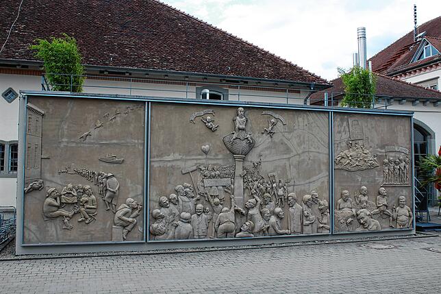 Seitlich vom Zollhaus fasziniert das Relief von Peter Lenk die Touristen immer aufs Neue. Es trägt den Titel &bdquo;Ludwigs Erbe&ldquo; ...