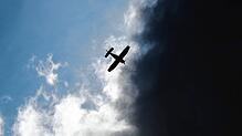 Ein Kleinflugzeug fliegt vor dunklen Wolken im Landkreis Hildesheim (Symbolbild).