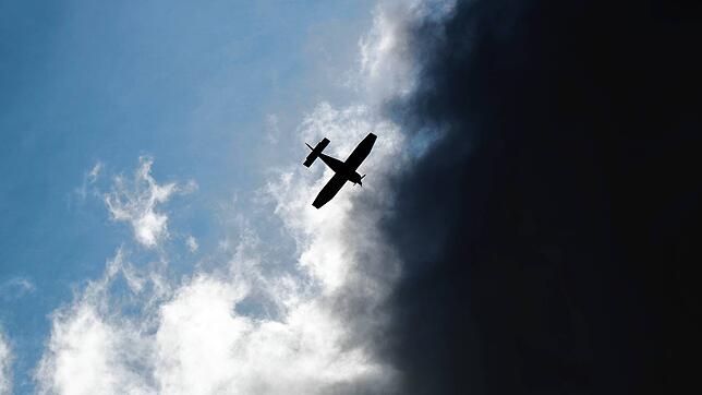 Ein Kleinflugzeug fliegt vor dunklen Wolken im Landkreis Hildesheim (Symbolbild).