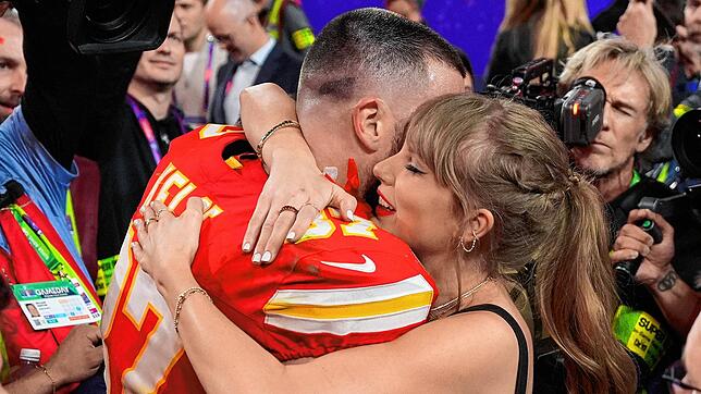 Taylor Swift küsst Kansas City Chiefs Tight End Travis Kelce nach einem Sieg. Travis Kelce und Taylor Swift sind ein Paar.