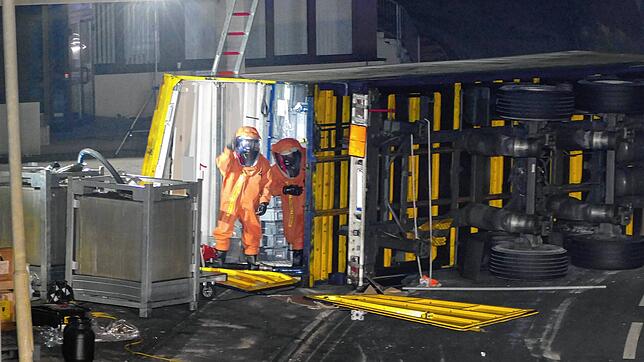 Der umgekippte Anhänger in der Kurve. Die Feuerwehr musste Chemikalien-Spezialanzüge tragen.
