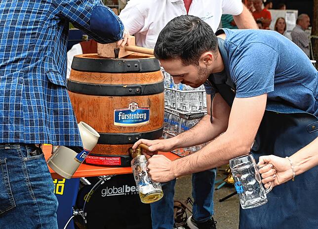 Der Bürgermeister hilft beim Bierzapfen.