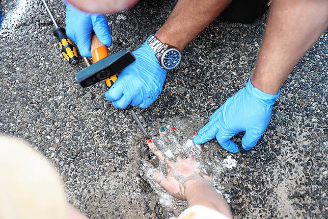 Mit Hammer und Schraubenzieher wird hier versucht, eine Hand zu lösen.