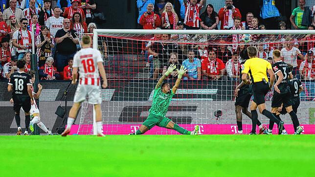 Jakub Kaminski ( 1. FC Köln, l) erzielt das Tor zum 1:0 das der Freiburger Torwart Noah Atubolu (M) nicht verhindern kann.