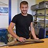 Alexander Merkt, Leiter einer Werkstattgruppe im St. Josefshaus, schleift die alte Daube ab, um die Maserung wieder sichtbar zu machen. ...