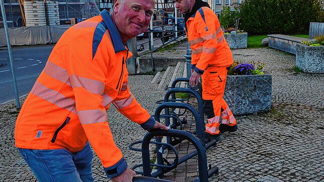 Stefan Mutter und Philipp Großhard vom Bauhof bringen den Fahrradständer auf dem Marktplatz in seine endgültige Position.