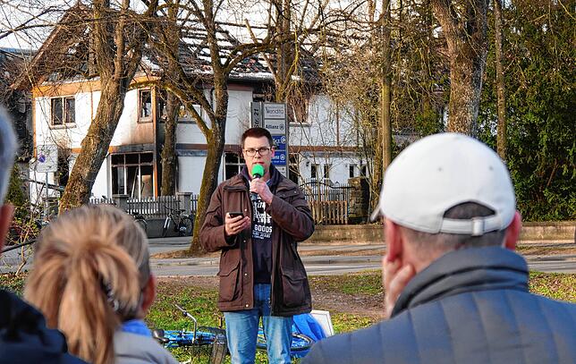 Gemeindeleiter Maximilian Stroscher bei einem Gottesdienst kurz nach der Brandnacht. Im Hintergrund sind Teile der zerstörten ...