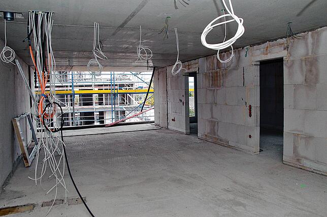 Blick vom Eingangsbereich in den Wohn- und Essbereich mit Balkon einer Dreizimmerwohnung im Haus Nummer vier. Hier sind die Arbeiten ...