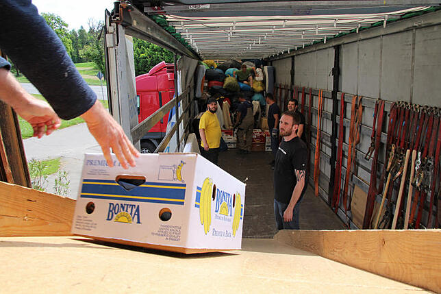 Hunderte bepackter Bananenschachteln über die Rutsche in den Schlund der Lkw.