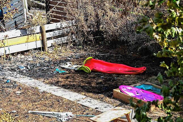 Eine geschmolzene Kinderschaukel. Noch vor ein paar Tagen drang hier unbeschwertes Kinderlachen aus dem Garten.
