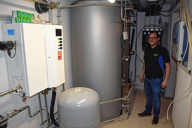 Der Vereinsvorsitzende Thomas Braun neben der neuen Heizungsanlage des Alten Schulhauses in Altenschwand.