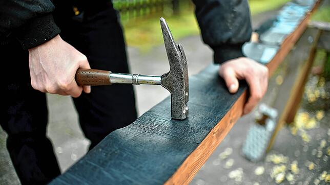 Ein Auszubildender befestigt Dachpappe. Ab 11. Mai dürfen deutsche Handwerker begonnene Projekte in der Schweiz abschließen. (Symbolbild)