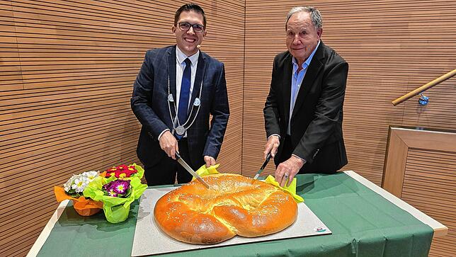 Beim obligatorischen Anschnitt der Neujahrsbrezel: Bürgermeister Dominik Männle und Hans-Joachim Jaeger, Ehrenbürger der Gemeinde und ...