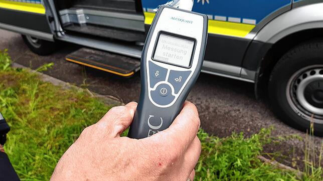 Unser Symbolbild vom 5. Mai 2022 zeigt einen Polizisten, der ein einen Alcomaten in der Hand hält, mit welchem der Atemalkohol getestet ...